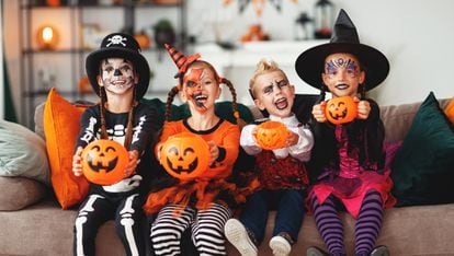 Several children dressed in Halloween show their pumpkins