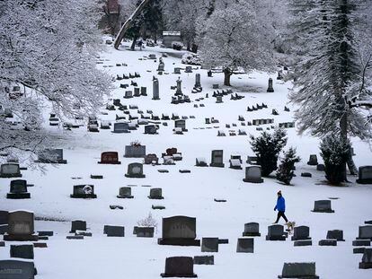 A man walks through the snow covered Mount Lebanon Cemetery in Mount Lebanon, Pennsylvania, on January 23, 2023.