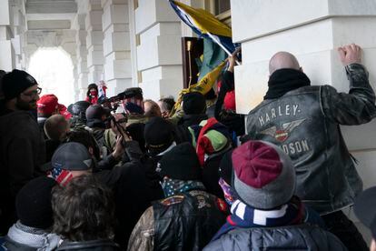 Insurrectionists loyal to President Donald Trump try to open a door of the U.S. Capitol as they riot in Washington, Jan. 6, 2021.