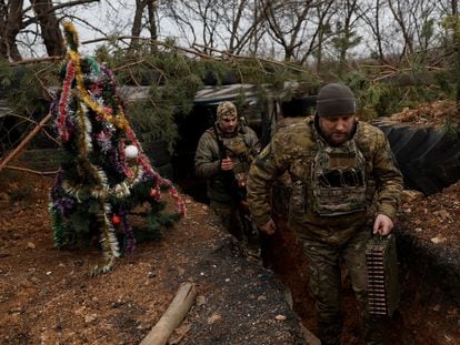 Ukrainian soldiers in a trench in Dnipro next to which they have erected a Christmas tree, December 24, 2022.