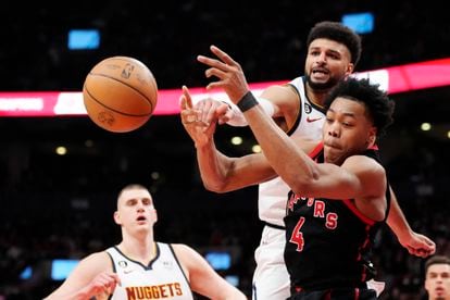 Denver Nuggets guard Jamal Murray and Toronto Raptors forward Scottie Barnes (4) vie for the ball during the first half of an NBA basketball game Tuesday, March 14, 2023, in Toronto.