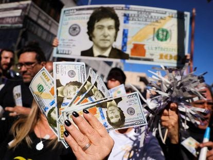 Supporters of Javier Milei wave replica dollar bills with his face on them at a rally in Buenos Aires.
