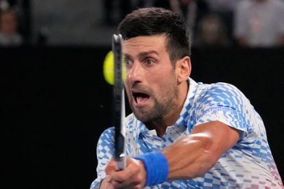 Novak Djokovic of Serbia plays a backhand return to Andrey Rublev of Russia during their quarterfinal match at the Australian Open tennis championship in Melbourne, Australia, Wednesday, Jan. 25, 2023.