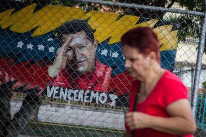 A woman walks past an image of Hugo Ch&aacute;vez, who hasn&#039;t been seen in public for nearly a month.