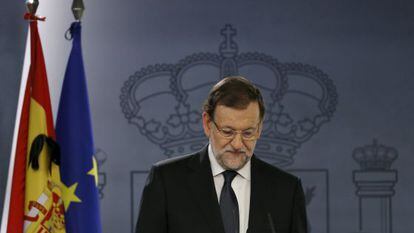 A black ribbon is seen on a Spanish flag as Prime Minister Mariano Rajoy speaks at La Moncloa.
