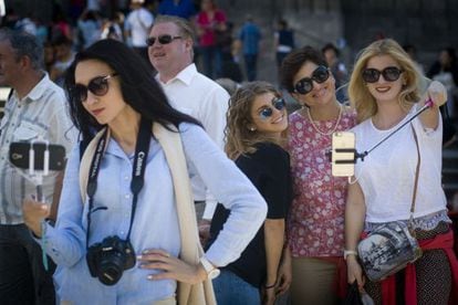 A group of tourists poses for selfies on Las Ramblas in Barcelona.