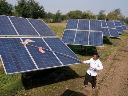 Farmer Pravinbhai Parmar cleans a solar panel installed at a farm in Dhundi village of Kheda district in western Indian Gujarat state, India, Friday, Jan. 13, 2023.