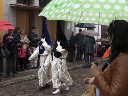 Two members of an Easter procession parade in the rain in Seville in 2012.