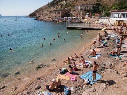 People gather at the beach area of the Black Sea, in Balaklava's bay, a part of Sevastopol on the Crimean Peninsula on Sunday, Aug. 9, 2015.
