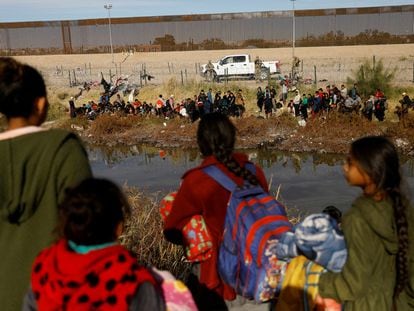 Migrants seeking asylum in the United States gather on the banks of the Rio Bravo river, as the Texas National Guard blocks the crossing at the border between the US and Mexico, as seen from Ciudad Juarez, Mexico December 5, 2023.