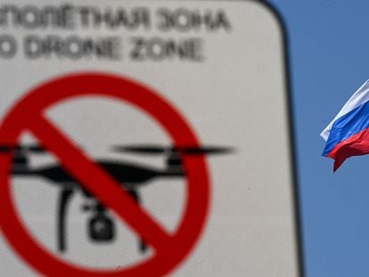 A "No Drone Zone" sign is pictured in front of the Russian national flag atop the Federation Council building, the upper chamber of Russia's parliament, in central Moscow.