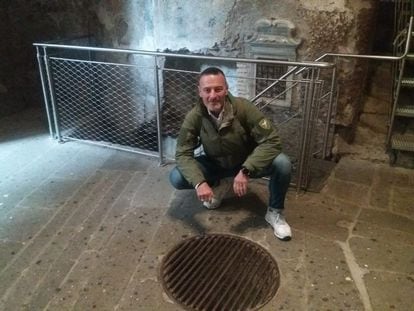 Massimiliano Colombo crouches in front of the entrance to the Tullianum dungeon. 