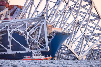 An emergency boat works alongside the container ship that crashed into the Francis Scott Key Bridge Tuesday in Baltimore. 