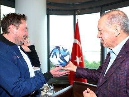 Turkey's President Tayyip Erdogan presents a ball as he meets with Tesla CEO Elon Musk in New York, U.S., September 17, 2023.