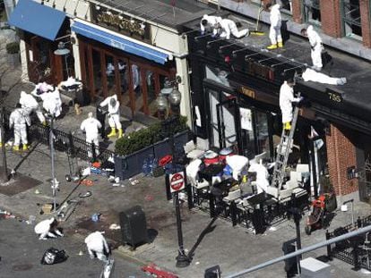 Investigators comb through the scene of one of the blast sites of the Boston Marathon explosions, Wednesday, April 17, 2013, in Boston. 
