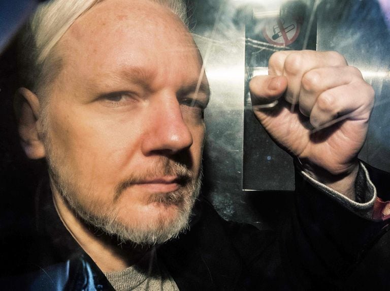 Julian Assange gesturing from the window of a prison van as he was driven into Southwark Crown Court in London on May 1, 2019 after Ecuador withdrew his asylum status.