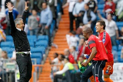 Sporting Gijón coach Manuel Preciado celebrates victory over Real Madrid with his players Gregory Arnolin and Raúl Domínguez.