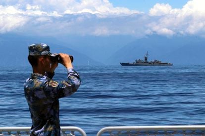 A Chinese soldier observes the movements of a frigate during maneuvers in the Strait of Formosa on August 5.