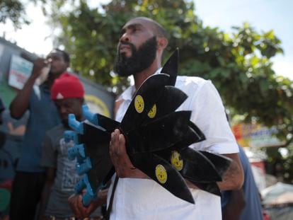 Nertil Marcelin, leader of a community group, holds a bunch of machetes to distribute to residents in an initiative to fight gangs seeking to take control of their neighborhood in the Delmas district of Port-au-Prince, Haiti, Sunday, May 28, 2023.