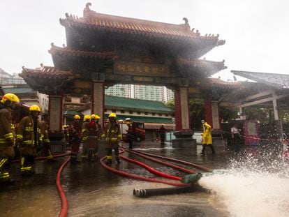 Fire-fighters drain out water following heavy rainstorms in Hong Kong, Friday, Sept. 8, 2023.