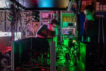 QuTecn researchers work on a quantum network node with mirrors and filters that guide laser beams to a diamond chip.
