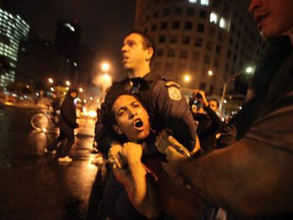 Police officers arrest a protestor on Tuesday night in Rio.