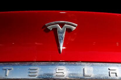 The Tesla company logo sits on an unsold 2020 Model X