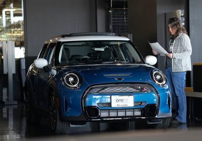 A potential buyer looks over an 2023 Cooper S sedan on the floor of a Mini dealership on Friday.