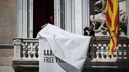 A banner in support of jailed separatist leaders is removed from Catalan government HQ.
