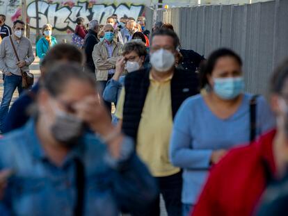 People wait in line for a rapid coronavirus antigen test in the Madrid neighbourhood of Vallecas.
