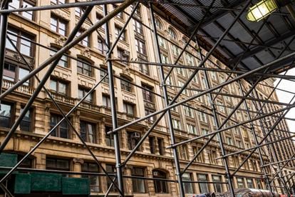 A building in New York surrounded by scaffolding, part of the metal and wood landscape that covers the metropolis