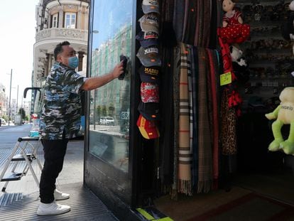 A worker cleans the window to a store in the center of Madrid.