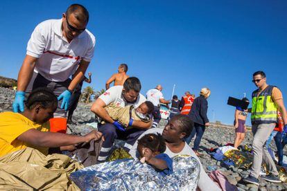 Members of the Red Cross help the migrants on Águila beach.
