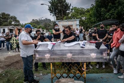 Relatives of Daniel Picazo place his soccer jerseys over his coffin.