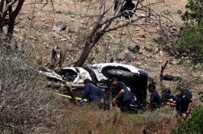 Forensic experts examine a destroyed police patrol car in Tlajomulco, a Guadalajara suburb, on July 12.