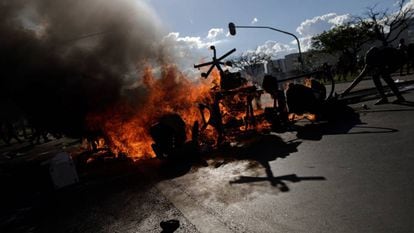 Protesters set fire to barricades in Brasilia using office furniture looted from ministry buildings.