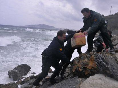 Civil Guard officers take one of the hashish packages out of the sea on Monday.