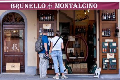Vacation costs are often a reason for conflict between partners. In the image, a couple looks art wine in a window in Tuscany, Italy.