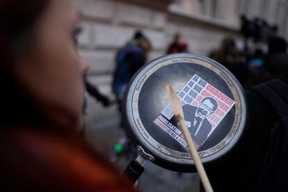 A woman bangs a pan with a sticker caricaturing Emmanuel Macron, after French President Emmanuel Macron tried to diffuse tensions in a televised address to the nation, Monday, April 17, 2023.