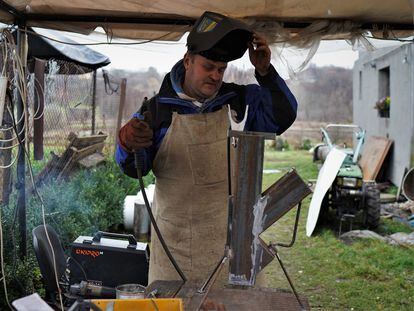 Ihor, a 47-year-old Protestant pastor, making a rocket stove in the village of Velyka Vilshanka, in the Kyiv region.