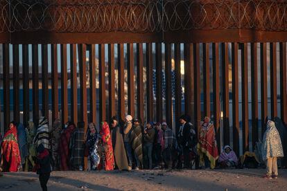 Migrants next to the border wall that separates Ciudad Juarez from El Paso, Texas, on December 22.
