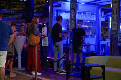 A temperature check is carried out at the door of a bar in Marbella, in southern Spain.