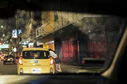 A young sex worker offers herself to a driver passing through the area of Comuna 14 in Medellín.