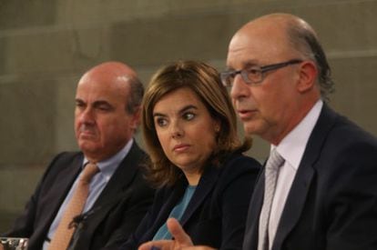Economy Minister Luis de Guindos, Deputy PM Soraya S&aacute;enz de Santamar&iacute;a and Finance Minister Crist&oacute;bal Montoro speak to the press on Friday. 