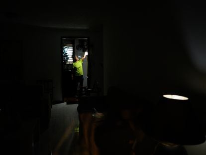 Carolina González turns on a rechargeable light bulb in the kitchen of her home during an electrical service failure, September 7.