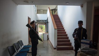 Two police officers guard the entrance to the offices of the newspaper ‘Confidencial’ on December 15, 2018.
