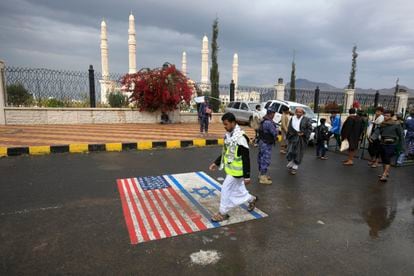 A Houthi supporter steps on drawings of the U.S. and Israeli flags in Sana'a after Washington declared the Houthis a terrorist group.