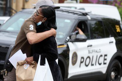 A man embraces a woman near the scene of the shooting at Tops Friendly Market in Buffalo, New York.