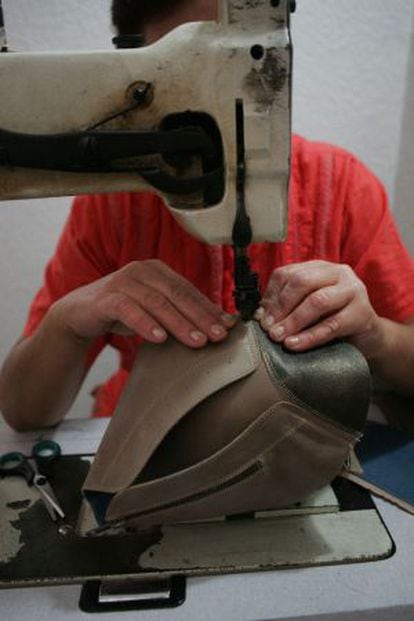 A woman stitches a boot in an illegal workshop in Alicante.
