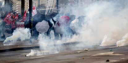Protesters protect themselves from tear gas during a march on Tuesday, March 28, in Nantes.